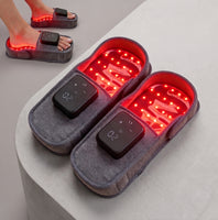 LumaSlips Red Light Therapy Slippers worn on feet, red LED panel illuminated